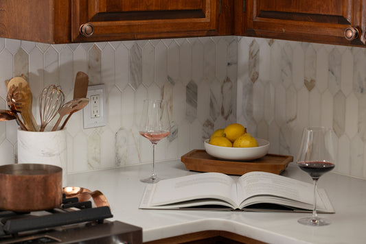 Wine glasses in kitchen with book and fruit